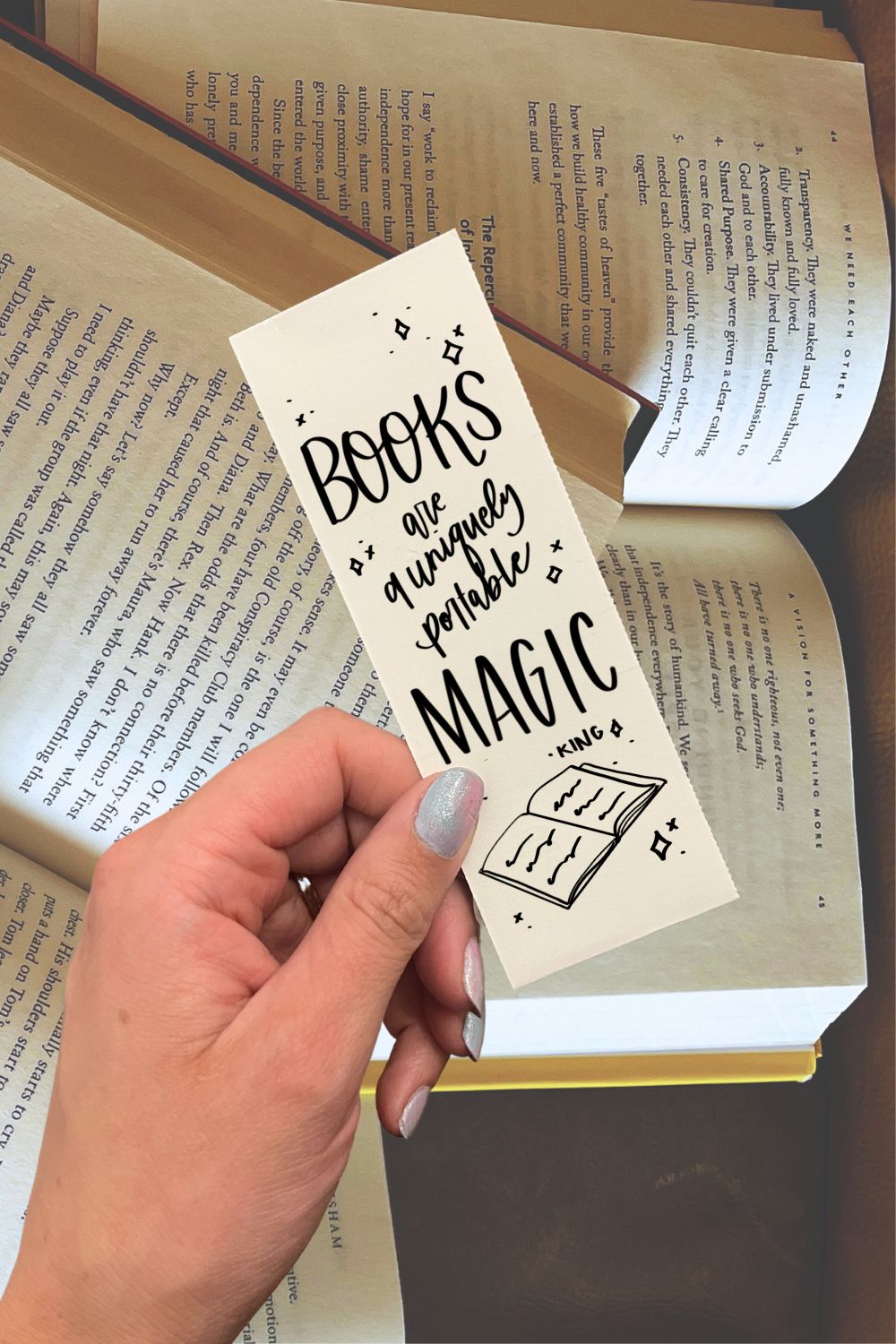 Free printable bookmarks with quotes about reading. The one being held reads: Books are a uniquely portable magic.