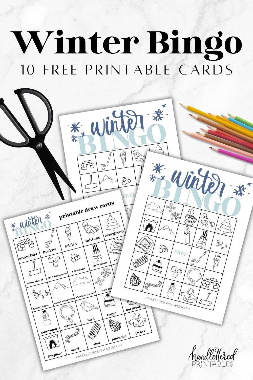 image of winter bingo cards printed on marble countertop with black scissors and pencil crayons. text over reads winter bingo 10 free printable cards