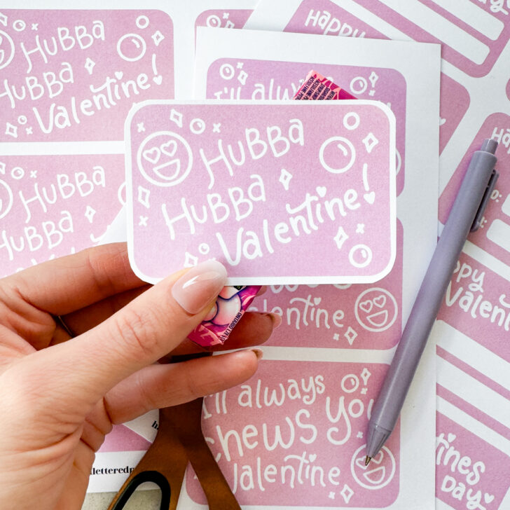 hubba hubba valentine cut with rounded corners and held with a pack of bubble gum free printables being cut to size on the countertop