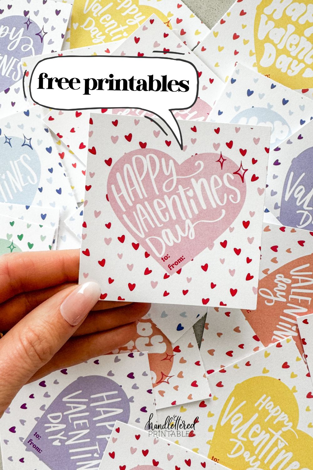 free printable happy valentines day cards in 6 candy colors (pink, purple, yellow, blue, orange, and green) image shows valentines cut to size (square), valentine reads 'happy valentines day' pink version being held text reads: free printables