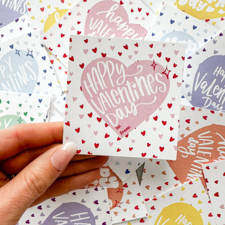 free printable happy valentines day cards in various candy colors shown cut to size (square), pink version being held