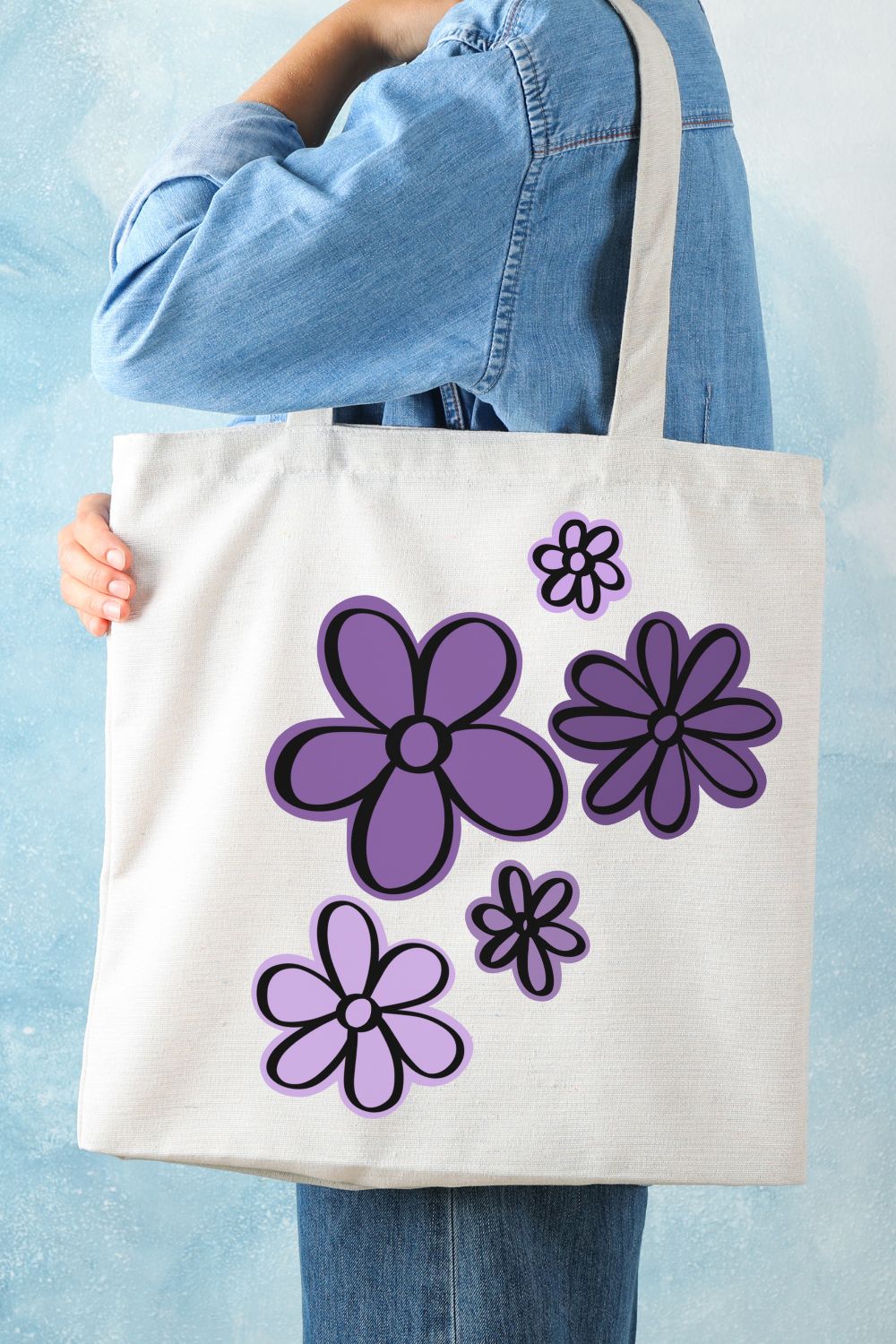 Free SVG- Hand Drawn flowers cut files shown cut with layers on a tote bag, the background layer is cut in a variety of purples and black outline