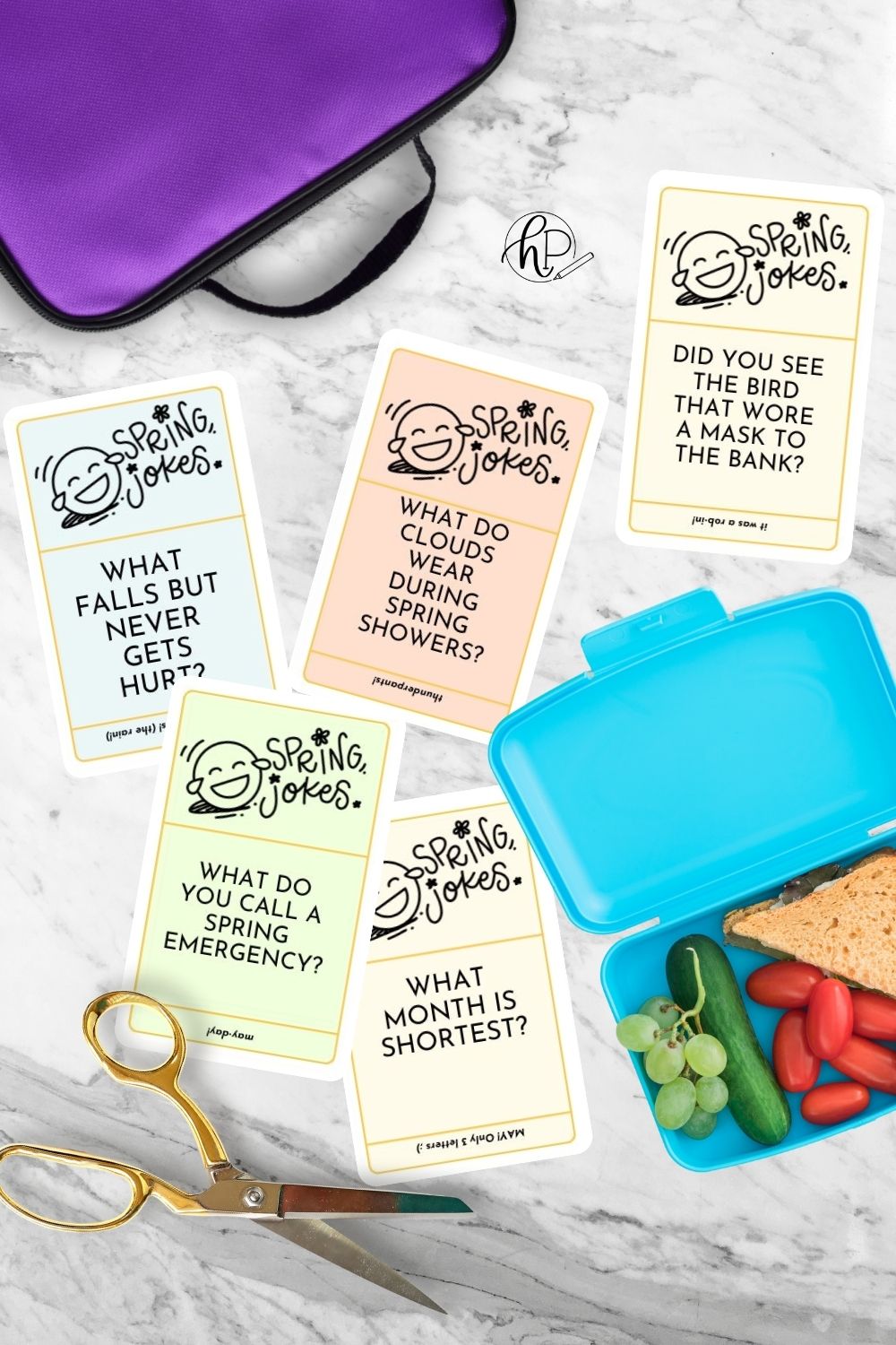 image of lunchbox and lunch packing on marble countertop with joke cards cut to size. joke cards printed in color with hand lettered title, illustrated laughing face emoji and easy to read jokes for kids.