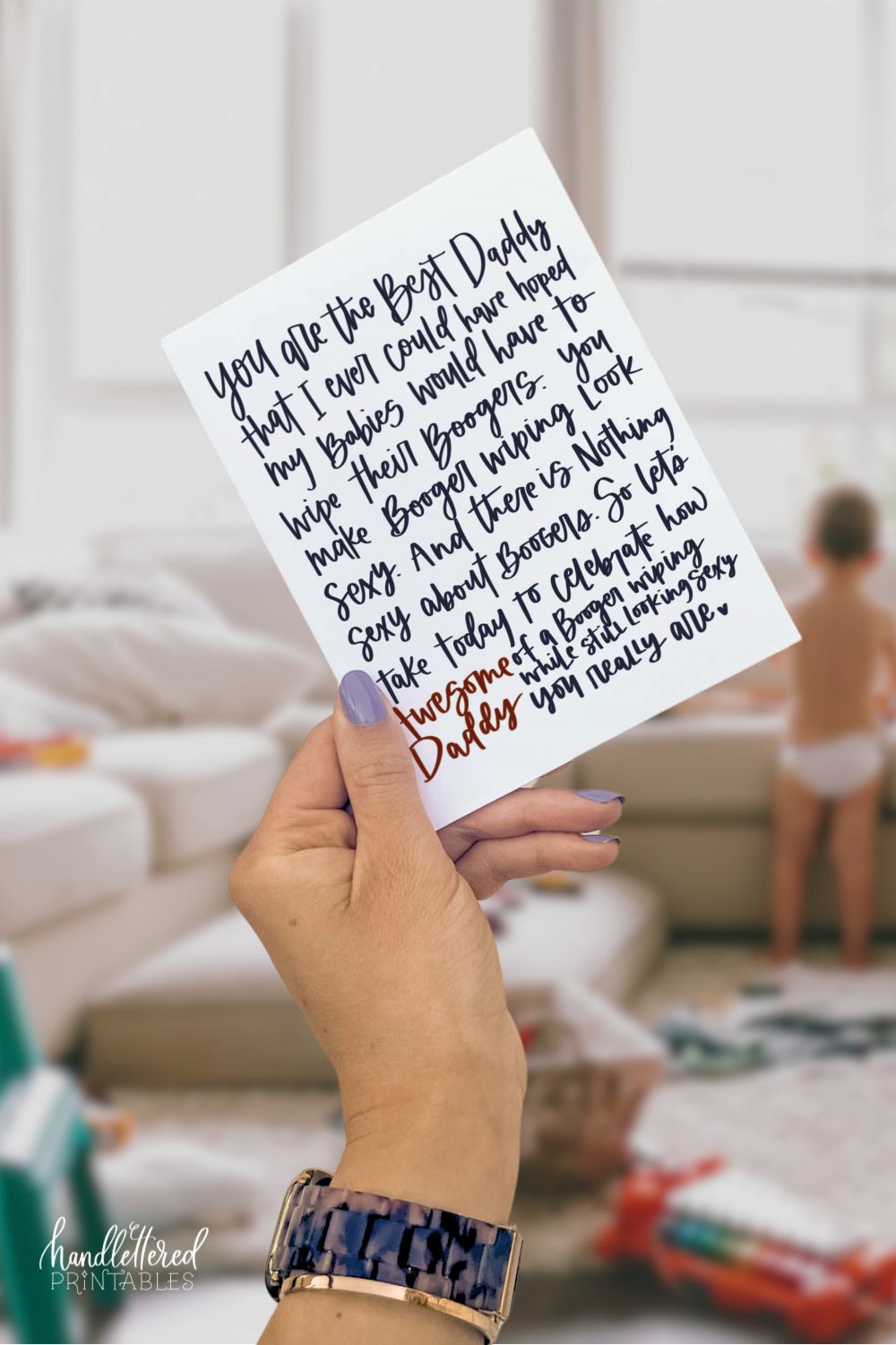 image of funny fathers day card: woman's hand holding a card in a messy living room with baby in the background. card reads: you are the best daddy that I could ever have hoped my babies would have to wipe their boogers. You make booger wiping look sexy. And there is nothing sexy about boogers. So let's take today to celebrate how awesome of a booger wiping while still looking sexy you really are.