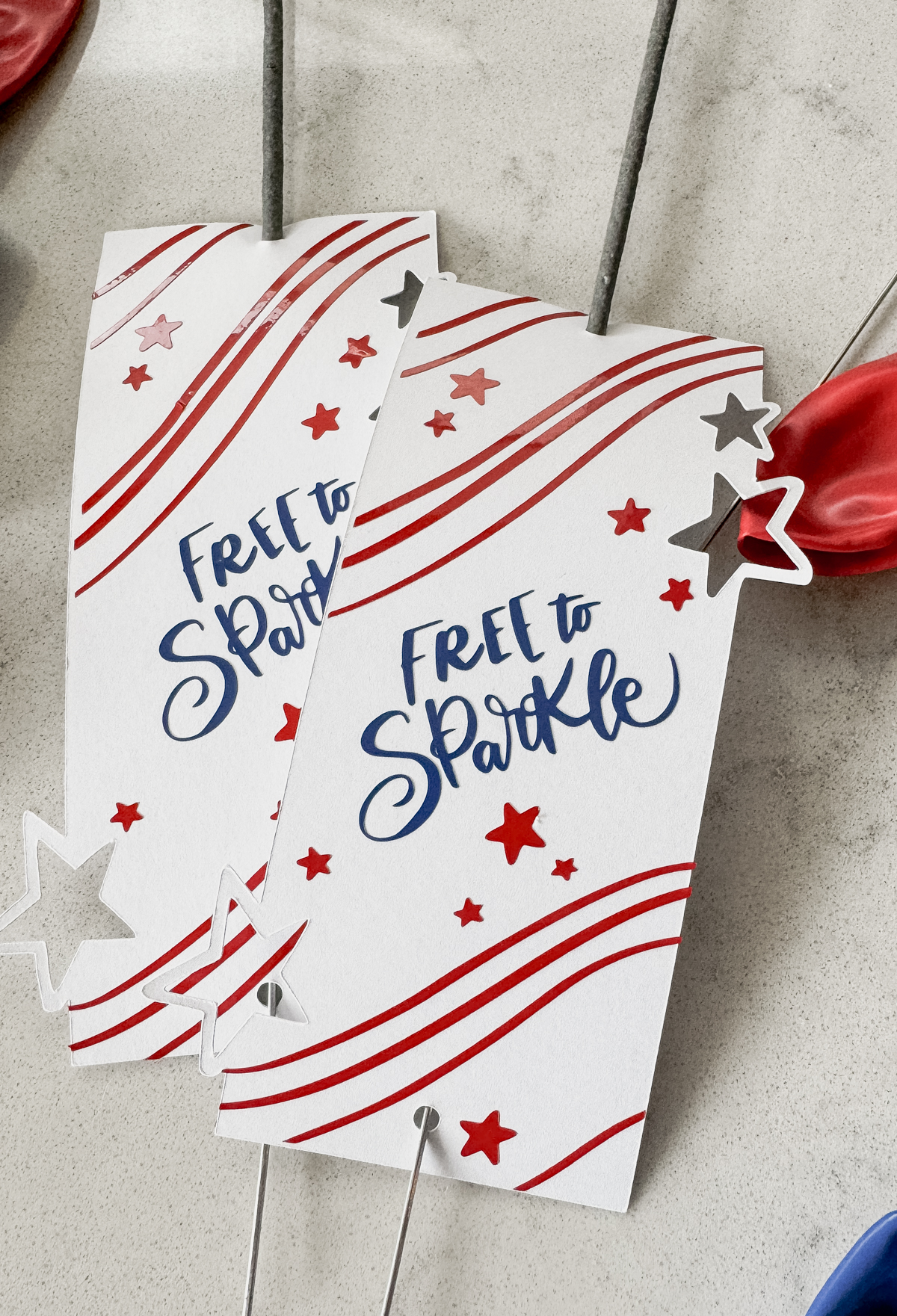 image of fourth of july sparklers holders free svg file with 3 layers, shown assembled with sparklers, on a countertop with red and blue balloons
