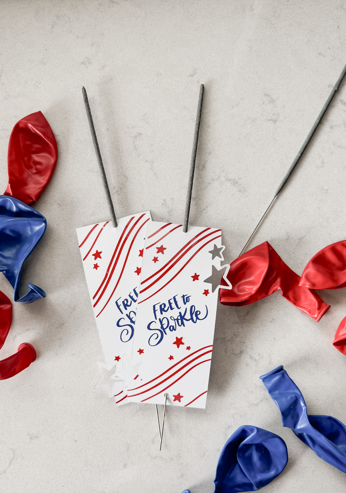 image of fourth of july sparklers holders free svg file with 3 layers, shown assembled with sparklers on countertop with red and blue balloons