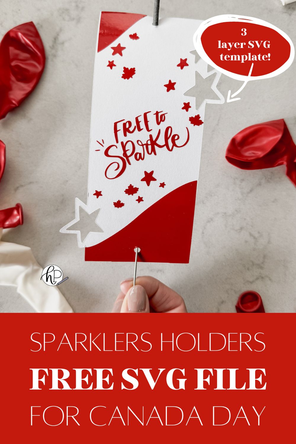 image of sparkler holder made with cricut- design has stars and maple leaves and the hand lettering 'free to sparkle' sparkler holder shown held over marble countertop with red and white balloons text overlay reads: sparklers holders free SVG file for canada day, 3 layer SVG template!